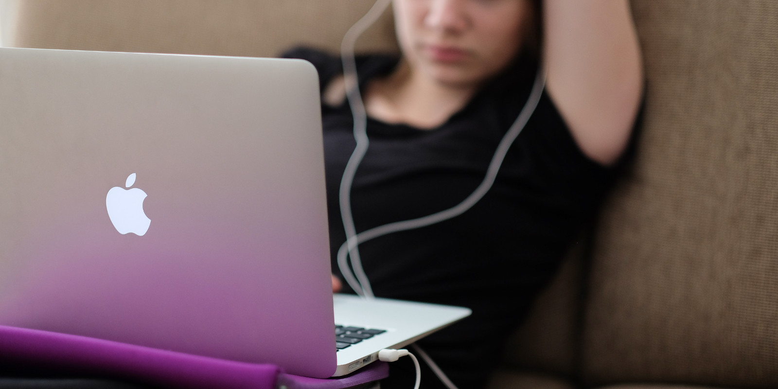 Woman with a MacBook on a sofa (adapted) (Image by Steinar Engeland [CC0 Public Domain] via Unsplash)