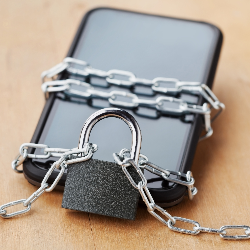 Ein Smartphone, dass mit Schloss und Kette gesperrt ist