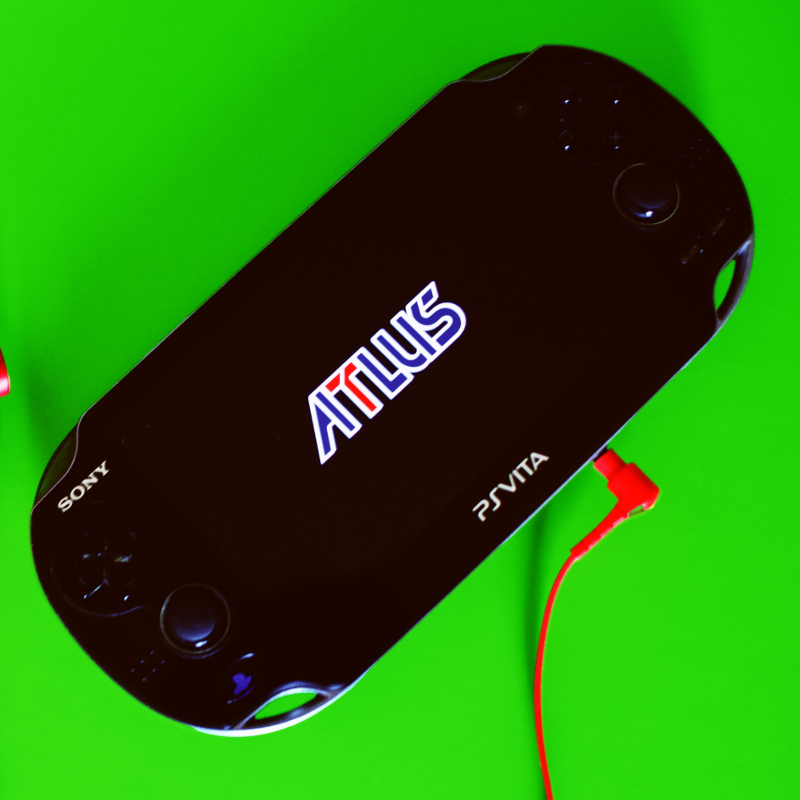 Die Playstation Vita mit einem Spiel von Atlus