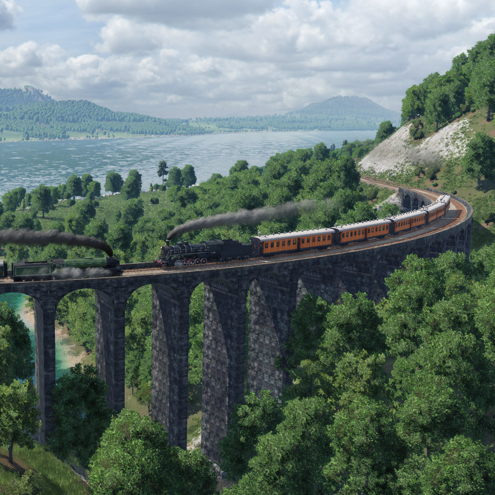 Zwei Dampfloks fahren in Transport Fever 2 auf einer großen Steinbrücke in idyllischer Insellandschaft aneinander vorbei.
