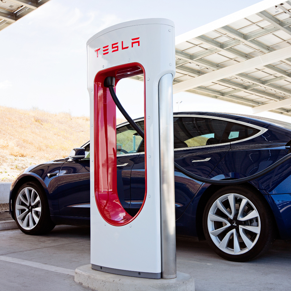 Ein Tesla E-Auto an einer Aufladesäule.