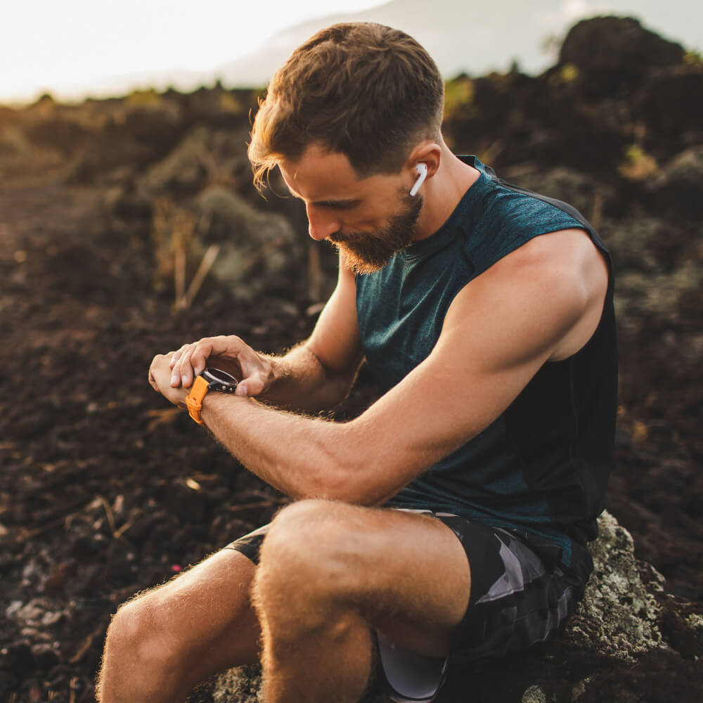 Ein Sportler prüft seinen Fitness Tracker.