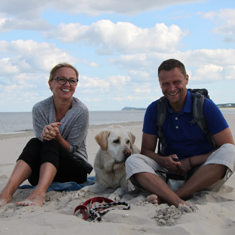 Dogsharing-Plattform Titelbild / Mann und Frau mit Hund am Strand