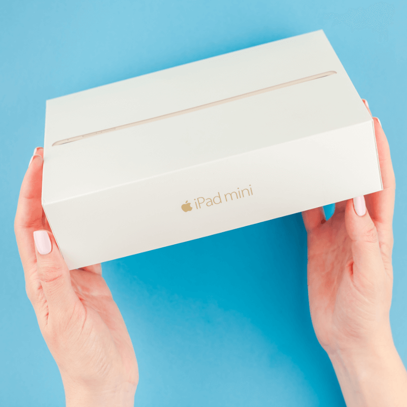 Weibliche Hände halten eine iPad Mini Box - Titelbild zu "iPad Mini der 5. Generation (2019) - Passt die kompakte Technik zu jedem?" / Foto von © dvoevnore via Adobe Stock