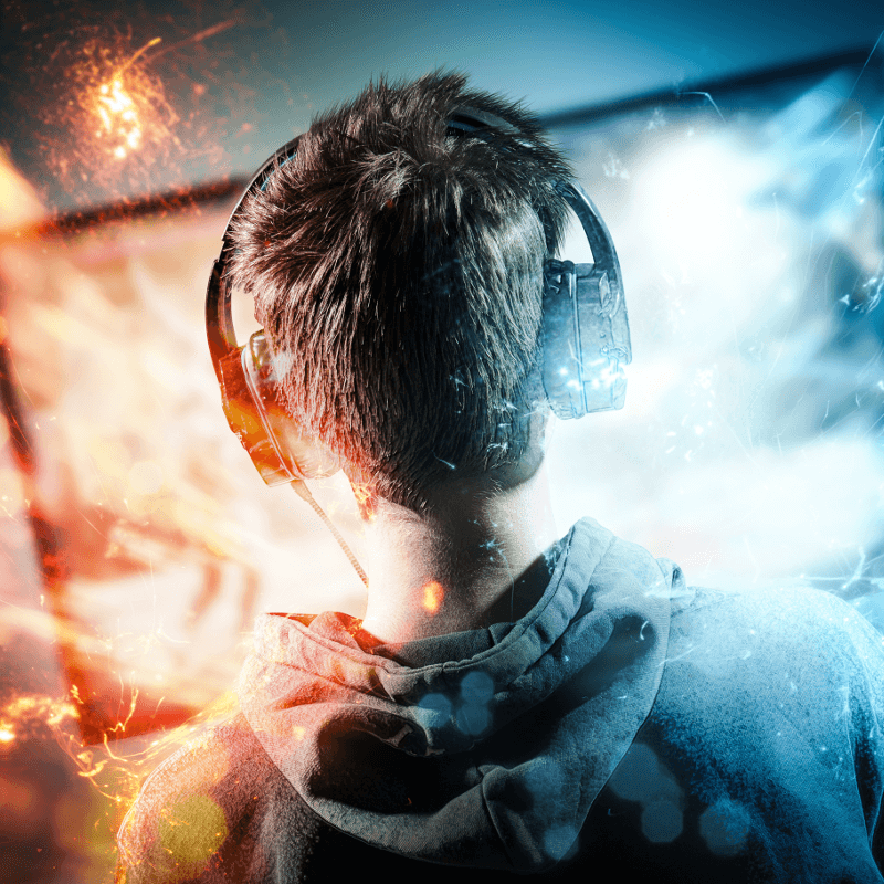 Junge mit Headset sitzt vor dem Monitor und lässt sich in den Bann ziehen