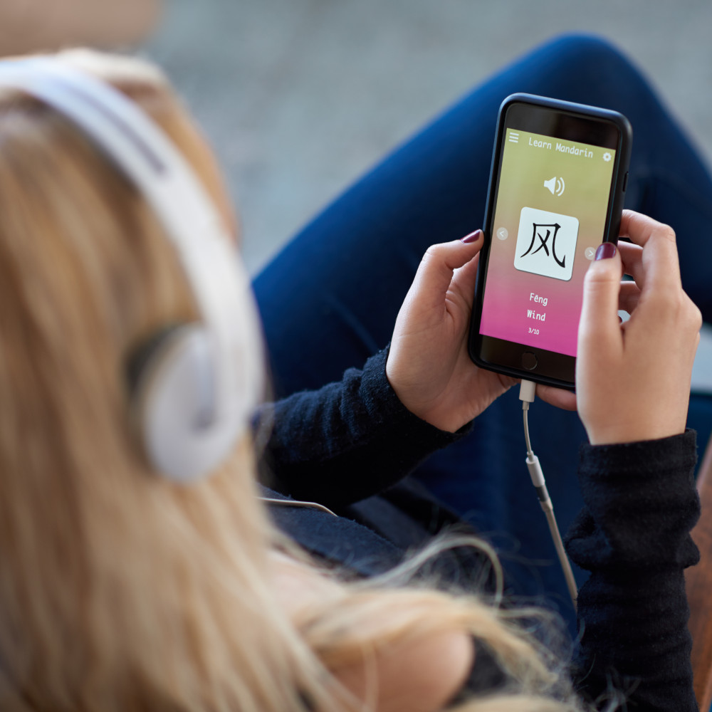 Eine Frau lernt eine Sprache mit einer Spaced Repetition App