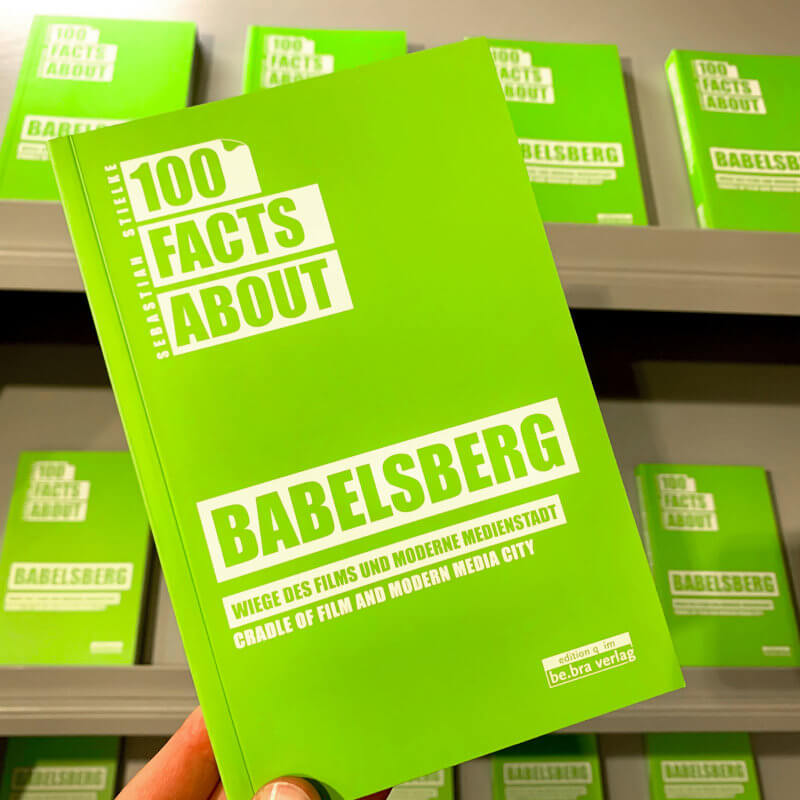 Das Buch "100 Facts about Babelsberg" in der Hand.