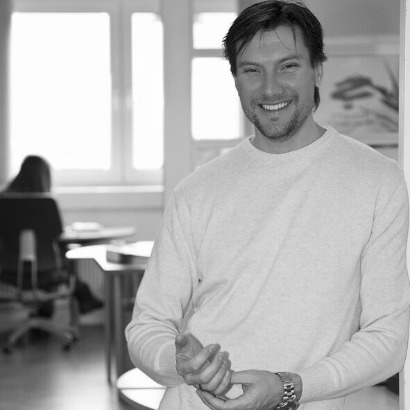 joachim Dierks in einem Büro, er lächelt und ist in Halbnah zu sehen.