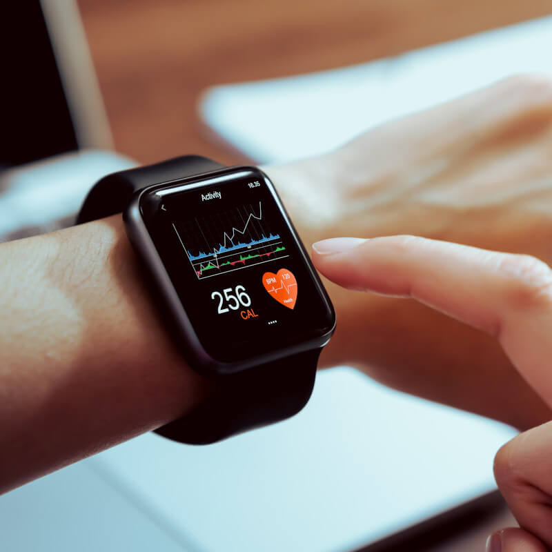 Eine Smartwatch am Handgelenk, die gerade Gesundheitsdaten anzeigt. Unter anderem den Kalorienverbrauch.