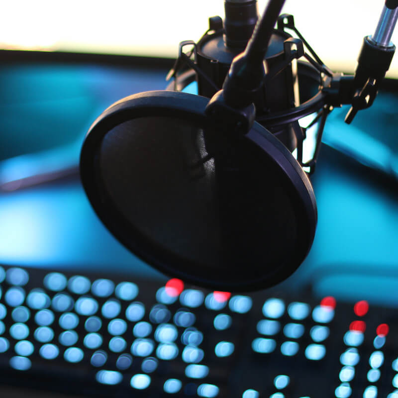Ein Mikrofon hängt vor einem Streaming-Rechner.