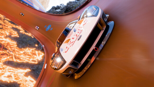 Ein Sportwagen fährt auf einer Hot Wheels-Strecke durch einen Vulkan, gefolgt von zwei anderen Autos im Hintergrund.
