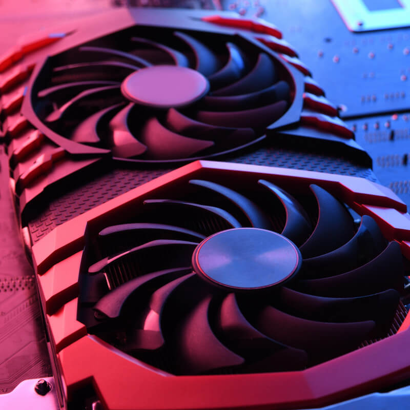 Eine Grafikkarte mit rotem und blauen Licht in Szene gesetzt. Im Hintergrund erkennt man ein Mainboard.
