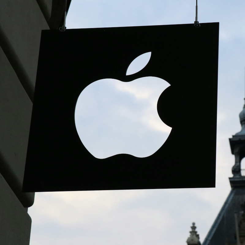 Schild eines Apple Stores in einer Altstadt, bei dem das Logo aus dem Schild rausgeschnitten ist.
