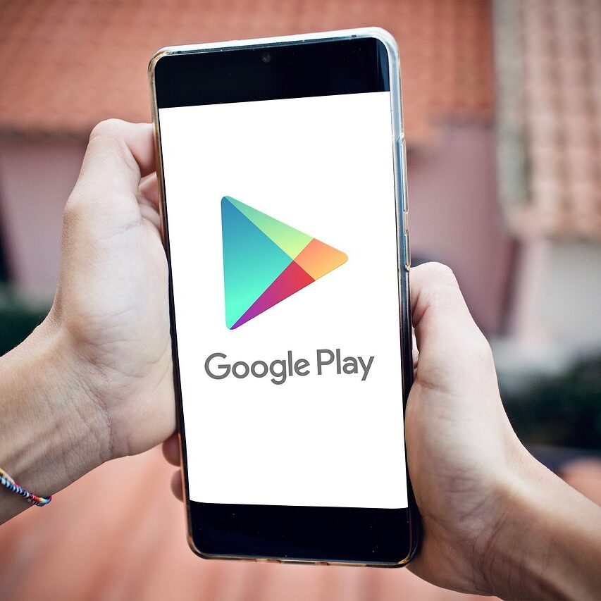 Bild von Victoria auf Pixabay, Smartphone in den Händen mit bild des Google Play Store Logos und Schriftzug