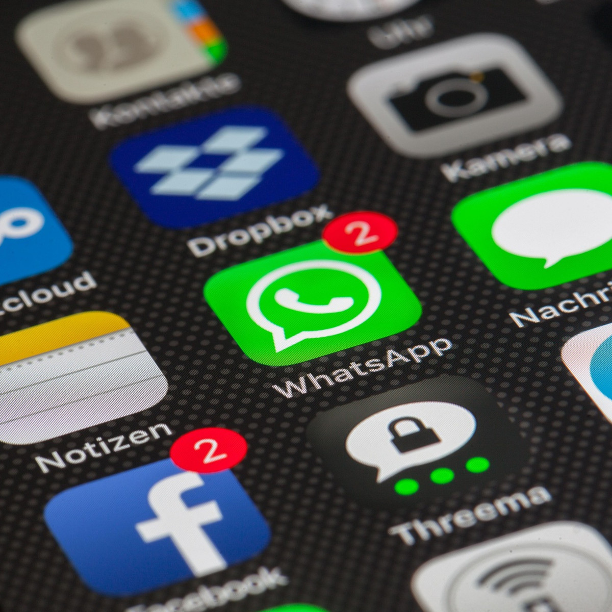 Mehrere Apps auf einem Smartphone. Im Mittelpunkt ist Whatsapp mit zwei neuen Nachrichten.