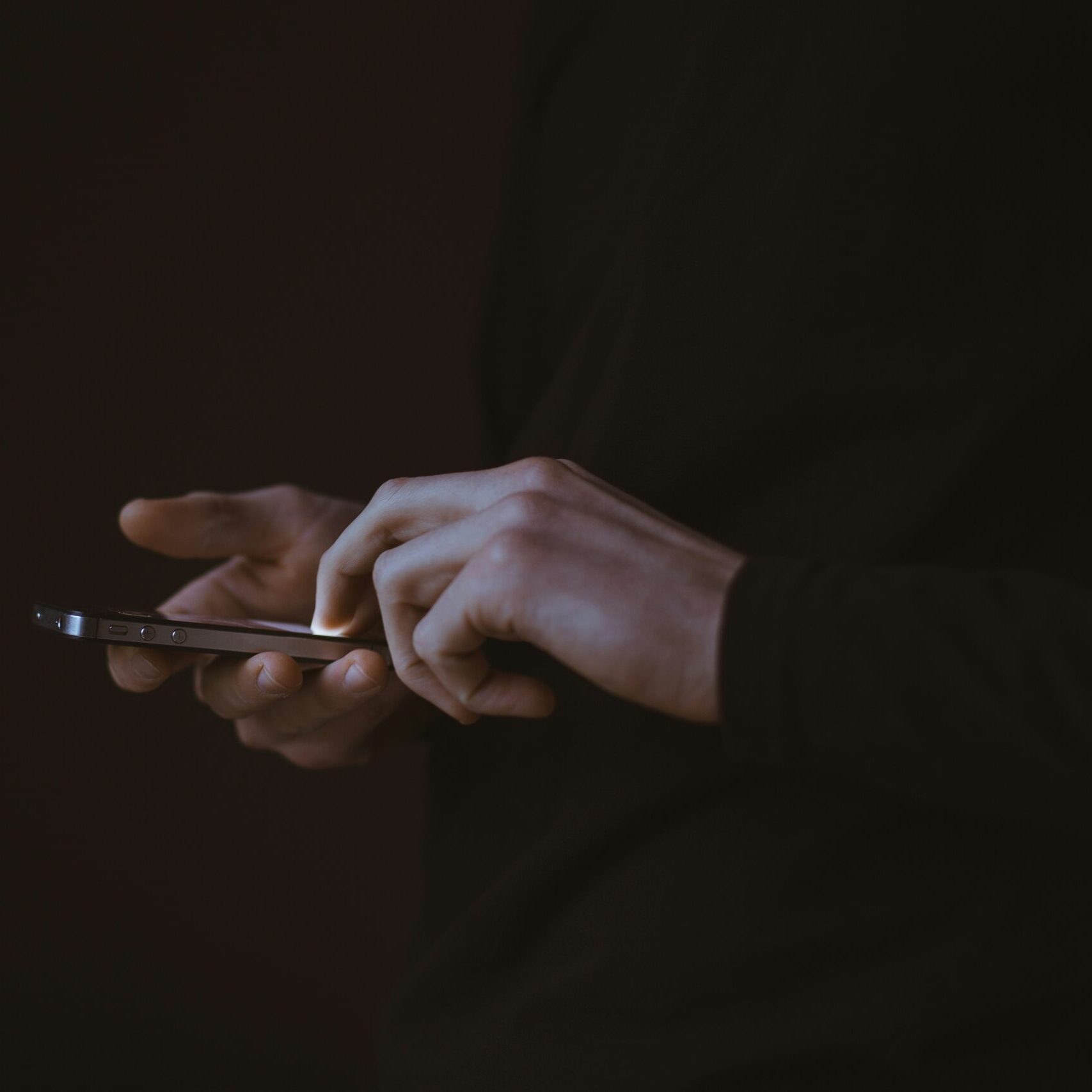 silhouette photo of person holding smartphone