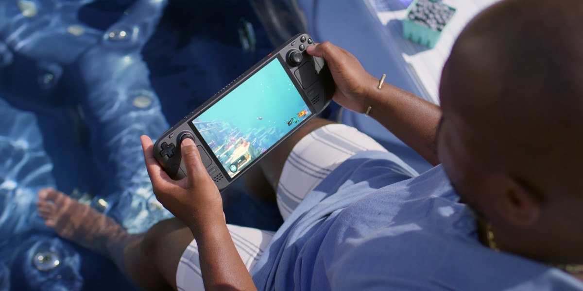 Ein Mann spielt auf dem Steam Deck OLED ein Spiel, das unter Wasser stattfindet, während er selbst an einem Pool sitzt und die Füße im Wasser hat.