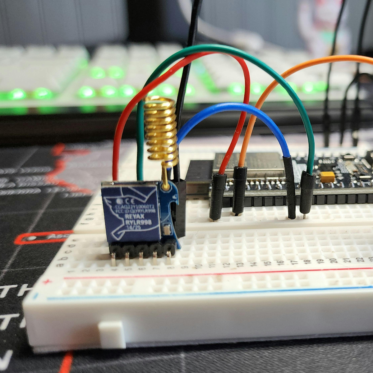Ein selbstgebautes Elektronikprojekt in der Nahaufnahme. Im Hintergrund ist verschwommen eine beleuchtete Tastatur zu sehen.