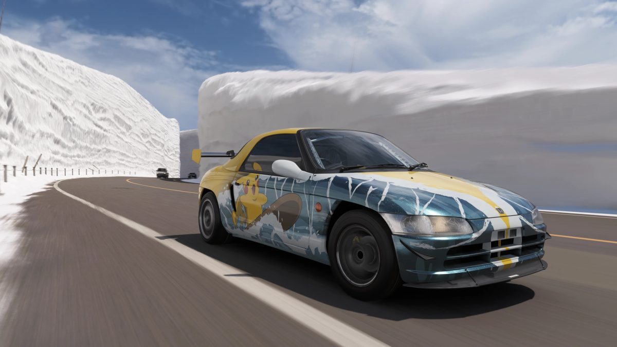 Ein Honda Beat fährt in einer surfenden Pikachu-Lakierung durch einen Schluch zwischen meterhohen Schneewänden.