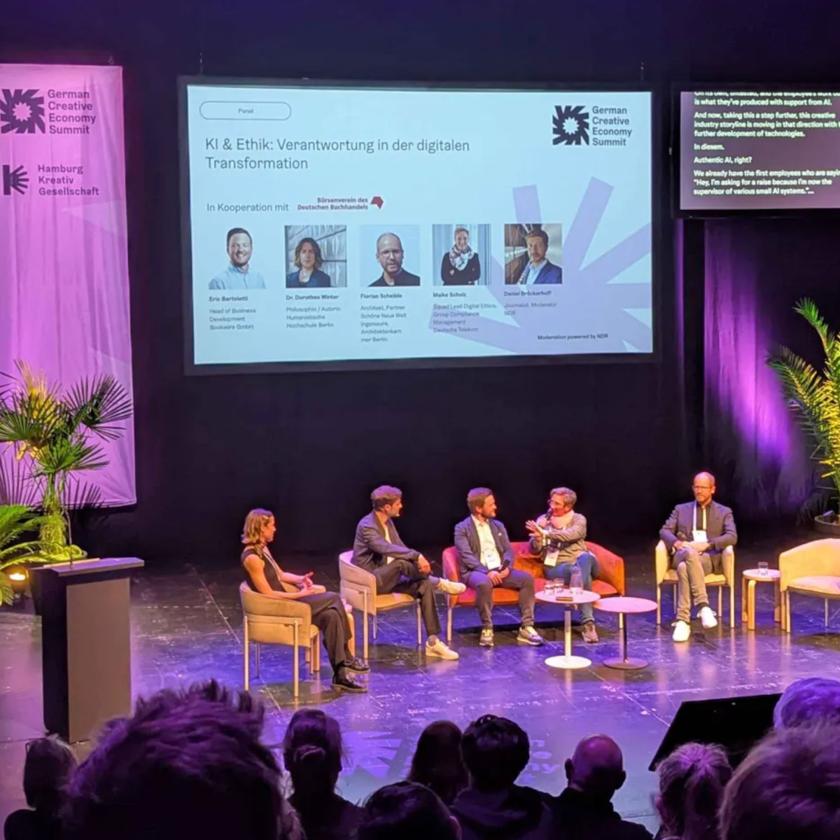 Fünf Personen unterhalten sich bei einer Panel-Diskussion auf einer Bühne, im Hintergrund ist das Logo des German Creative Economy Summit zu sehen